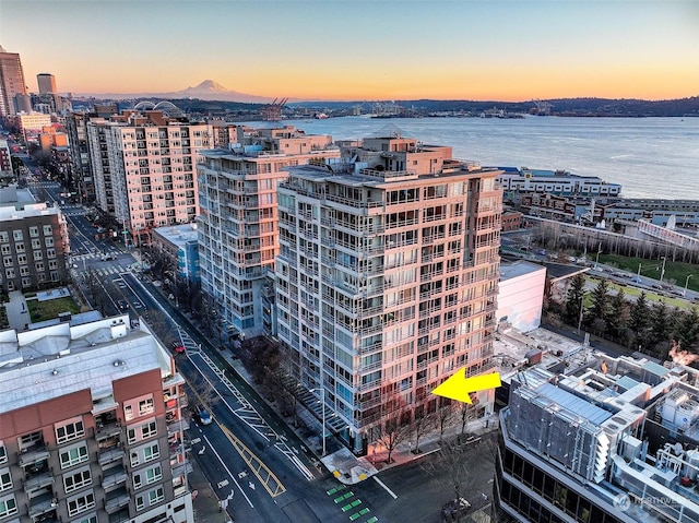 aerial view at dusk featuring a water view