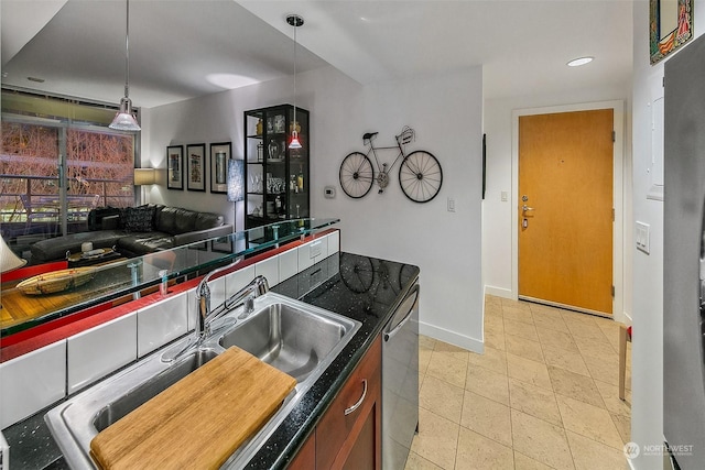 kitchen featuring sink, stainless steel dishwasher, and decorative light fixtures