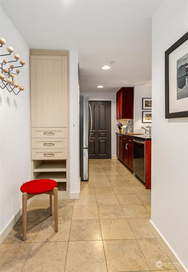 kitchen featuring stainless steel appliances, sink, light brown cabinets, and light tile patterned floors