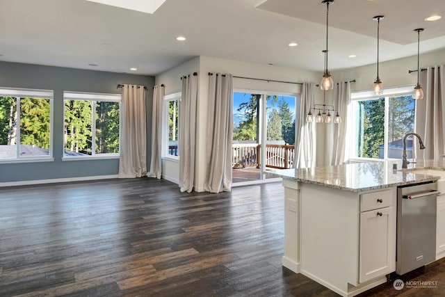 kitchen featuring dark wood-type flooring, light stone counters, decorative light fixtures, a wealth of natural light, and white cabinets