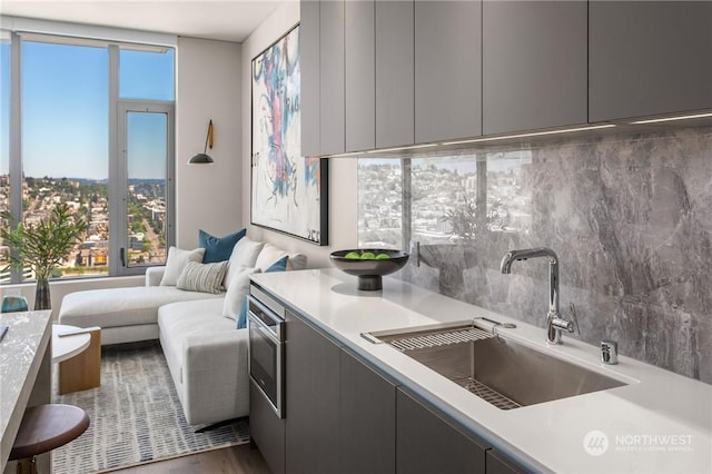 kitchen featuring tasteful backsplash, sink, and gray cabinetry