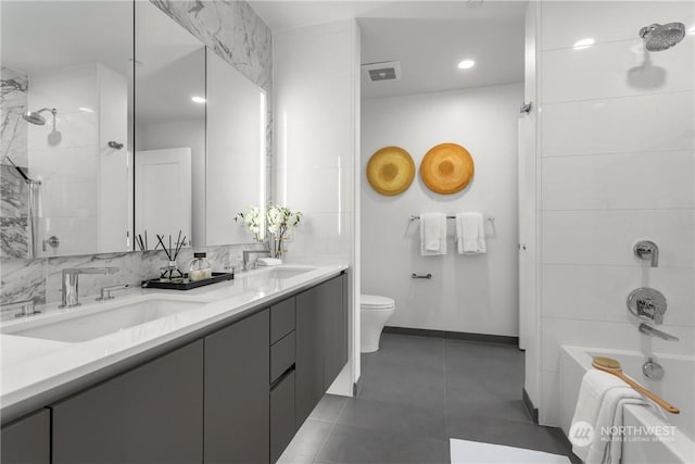 full bathroom featuring tiled shower / bath combo, vanity, tile patterned floors, and toilet