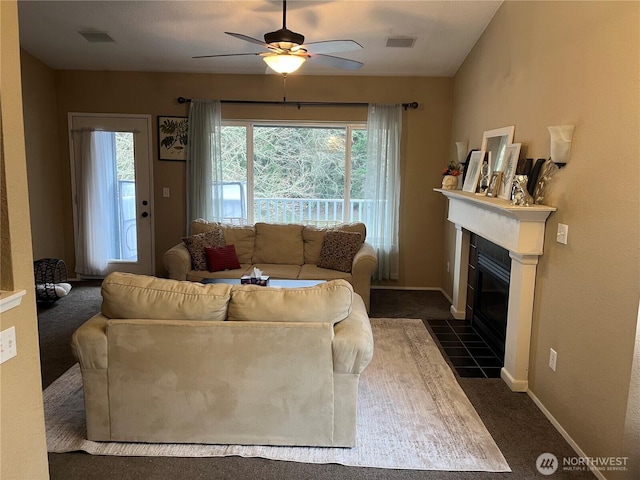 living room featuring a fireplace with flush hearth, visible vents, and plenty of natural light