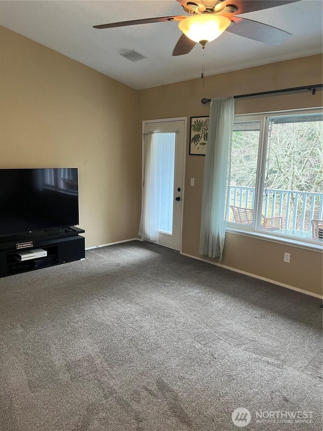 unfurnished living room featuring carpet floors, visible vents, ceiling fan, and baseboards