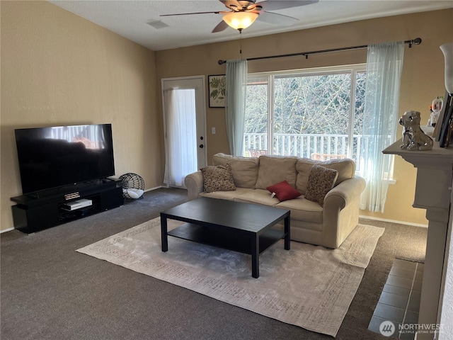 living area featuring carpet floors, baseboards, visible vents, and a ceiling fan