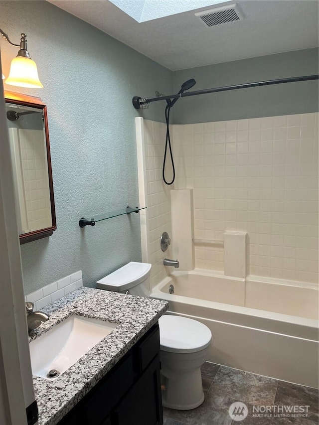 full bath with a textured wall, toilet, vanity, visible vents, and tub / shower combination