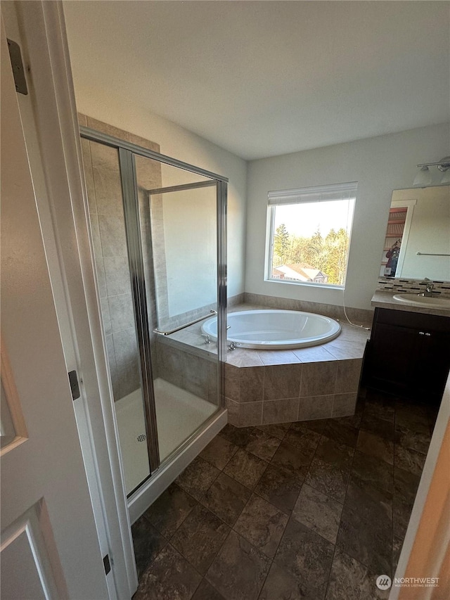 bathroom with vanity and shower with separate bathtub