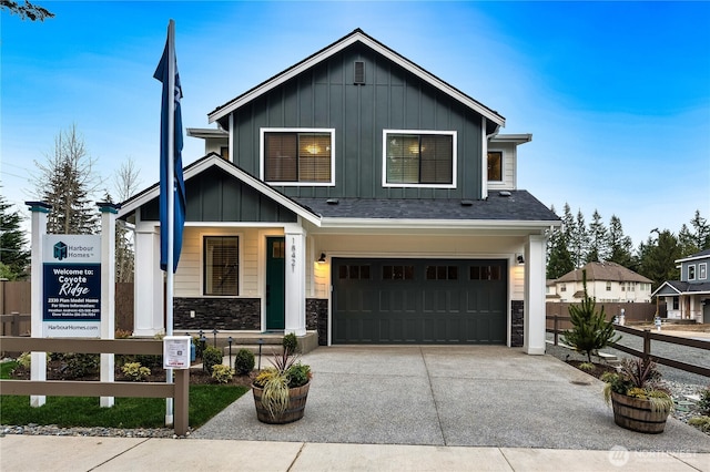 view of front of property with a porch, concrete driveway, a garage, stone siding, and board and batten siding