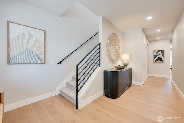 stairs with recessed lighting, wood finished floors, and baseboards