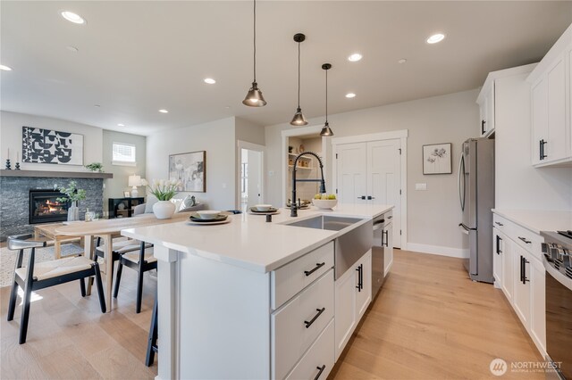 kitchen featuring a stone fireplace, a kitchen bar, recessed lighting, and freestanding refrigerator