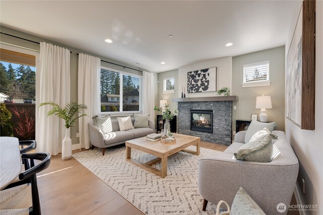 living area with recessed lighting, a fireplace, and wood finished floors