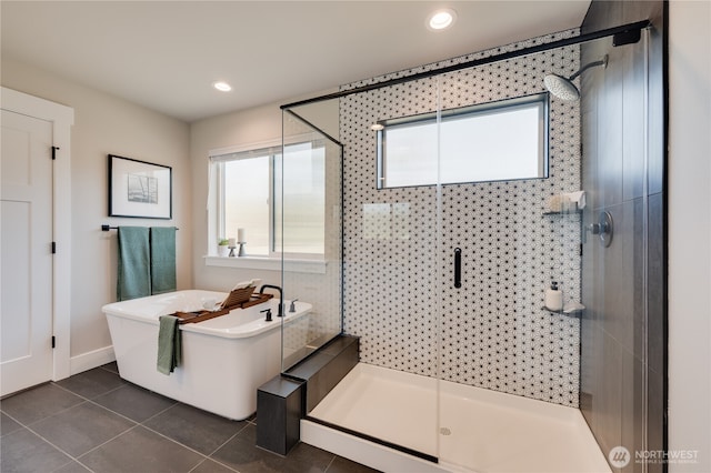 full bath featuring tile patterned floors, a freestanding tub, a healthy amount of sunlight, and a shower stall