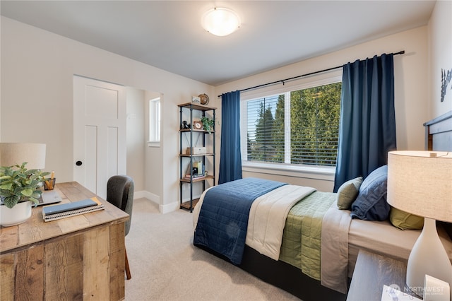 bedroom featuring baseboards and light colored carpet