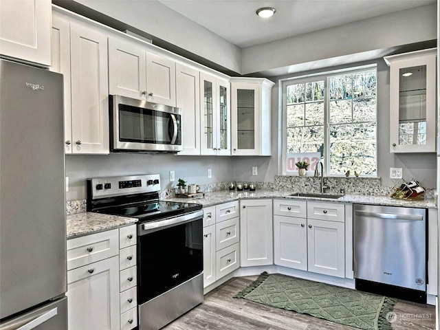 kitchen featuring stainless steel appliances, white cabinetry, and sink