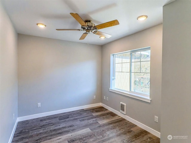 spare room featuring dark hardwood / wood-style flooring and ceiling fan