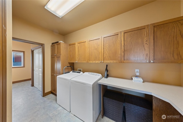 clothes washing area with cabinets and washer and clothes dryer