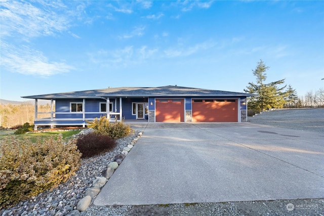 ranch-style house featuring a garage and covered porch