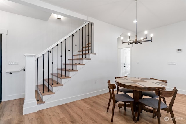 dining space with an inviting chandelier and light hardwood / wood-style flooring