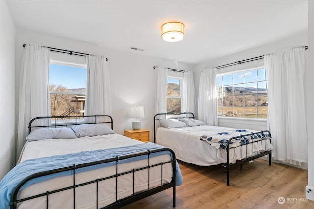 bedroom featuring hardwood / wood-style floors and a mountain view