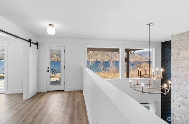 interior space featuring a water view, a barn door, and hardwood / wood-style floors