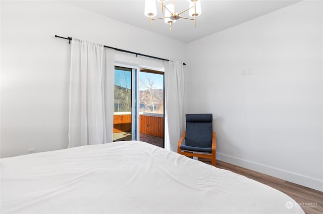 bedroom with hardwood / wood-style flooring, access to outside, and a chandelier