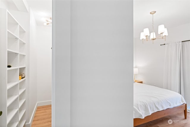 bedroom featuring hardwood / wood-style floors and a notable chandelier