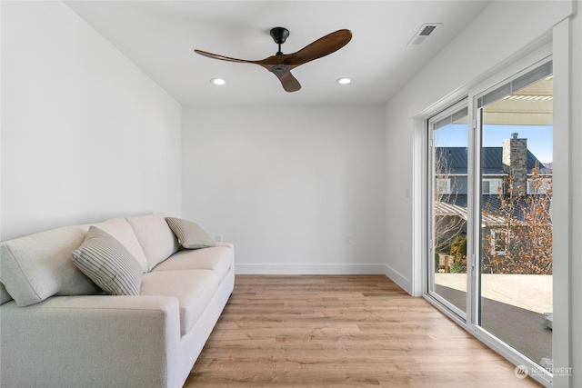 sitting room with ceiling fan and light wood-type flooring