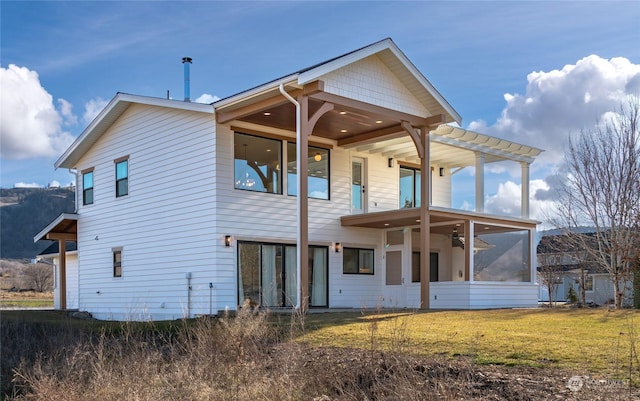 rear view of house with a yard and a sunroom