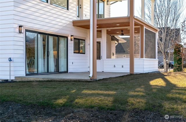 view of exterior entry featuring a patio and a lawn