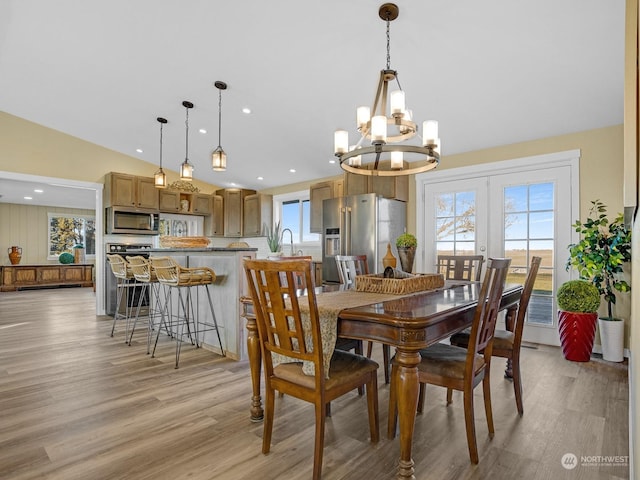 dining room featuring french doors, sink, vaulted ceiling, and light wood-type flooring