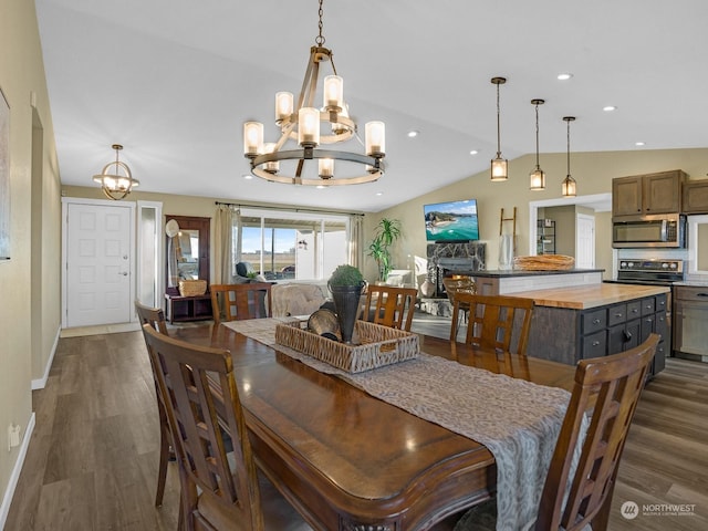 dining space featuring an inviting chandelier, lofted ceiling, and dark hardwood / wood-style floors