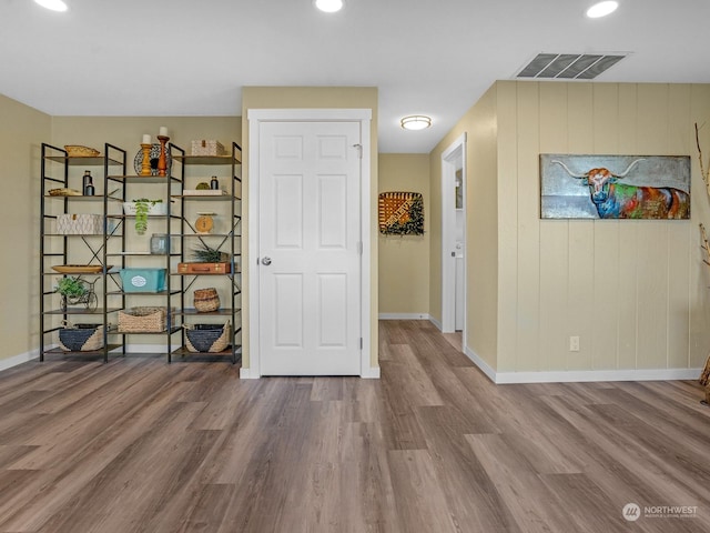 interior space with hardwood / wood-style flooring and wooden walls