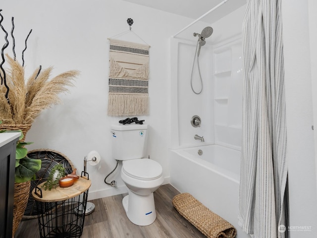 bathroom featuring hardwood / wood-style flooring, shower / bathtub combination with curtain, and toilet