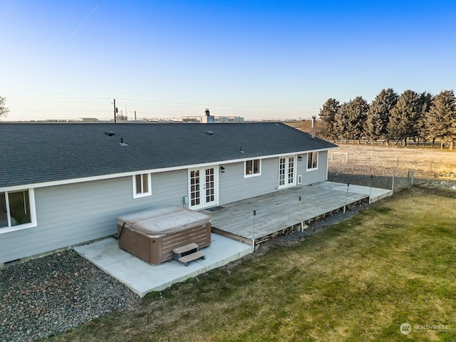 back of house with a hot tub, a wooden deck, a yard, and french doors