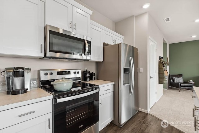 kitchen featuring dark wood-type flooring, stainless steel appliances, and white cabinets