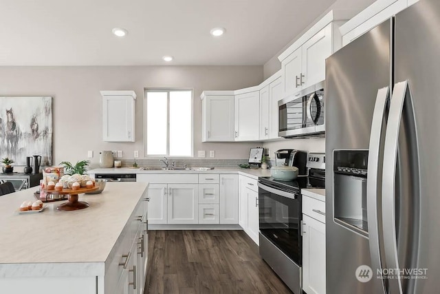 kitchen featuring white cabinetry, sink, dark hardwood / wood-style floors, and appliances with stainless steel finishes