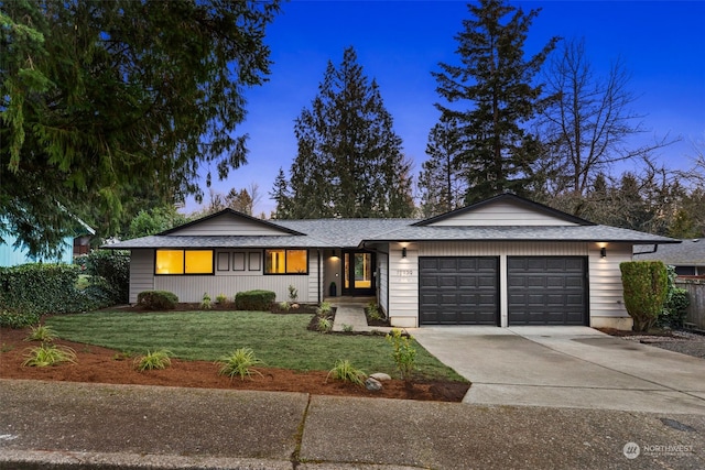 ranch-style house with a garage and a yard