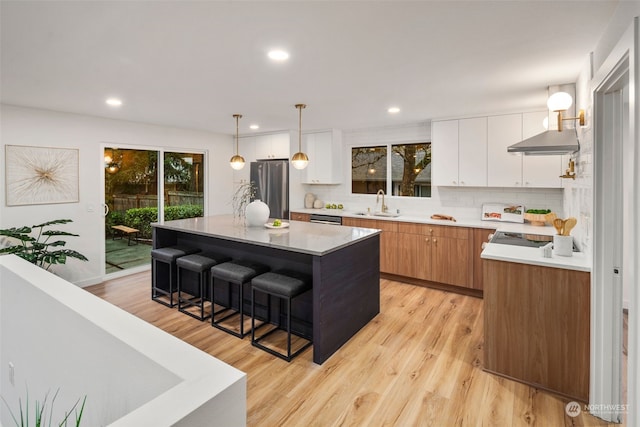 kitchen with sink, a breakfast bar area, stainless steel appliances, a center island, and white cabinets