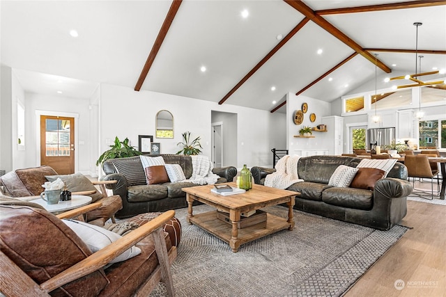 living room with high vaulted ceiling, light wood-type flooring, plenty of natural light, a notable chandelier, and beamed ceiling