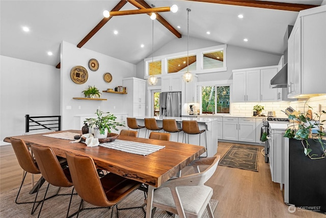 dining area featuring high vaulted ceiling, beam ceiling, and light hardwood / wood-style floors