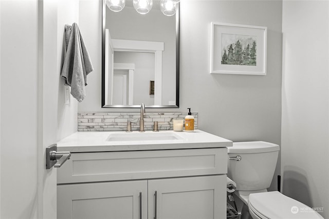 bathroom with vanity, backsplash, and toilet