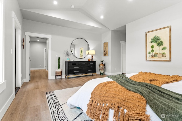 bedroom with vaulted ceiling and light hardwood / wood-style floors