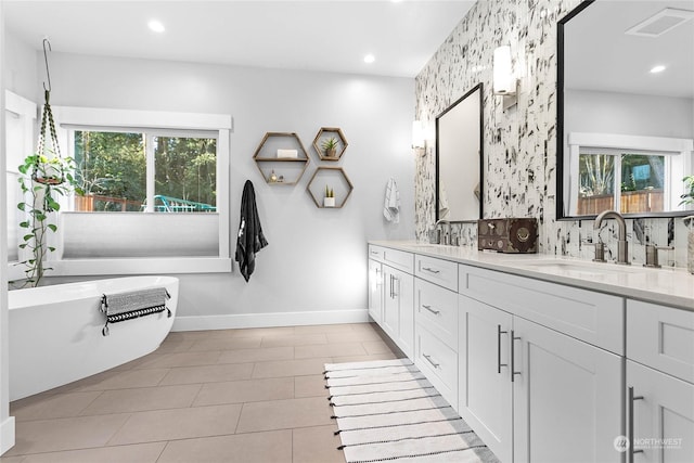 bathroom with vanity, tile patterned flooring, plenty of natural light, and tasteful backsplash