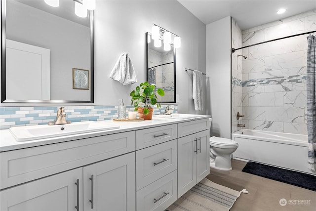 full bathroom with vanity, decorative backsplash, toilet, and tiled shower / bath combo