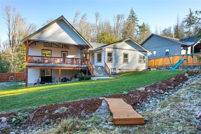 back of house with ceiling fan, a lawn, a playground, and a deck