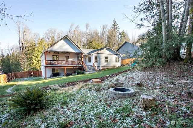 back of house featuring a yard and an outdoor fire pit