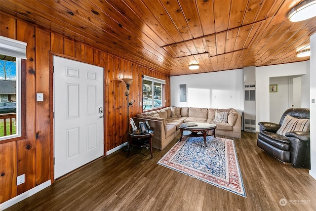 living room with dark wood-type flooring, plenty of natural light, wooden ceiling, and wood walls