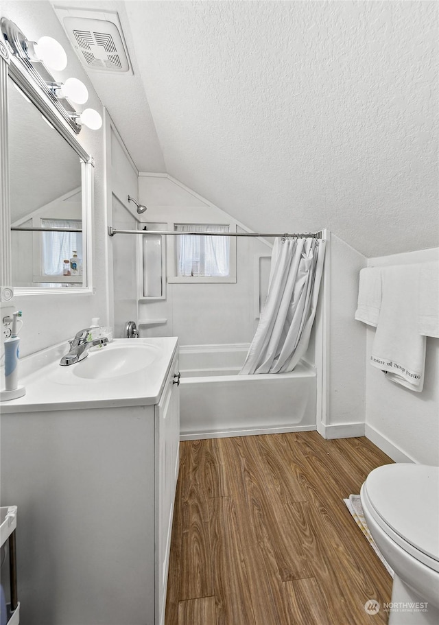 full bathroom with toilet, vaulted ceiling, vanity, shower / bath combo, and hardwood / wood-style floors