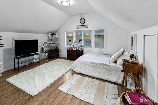 bedroom with vaulted ceiling and hardwood / wood-style floors