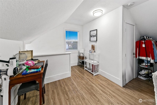 interior space with lofted ceiling, light hardwood / wood-style flooring, and a textured ceiling